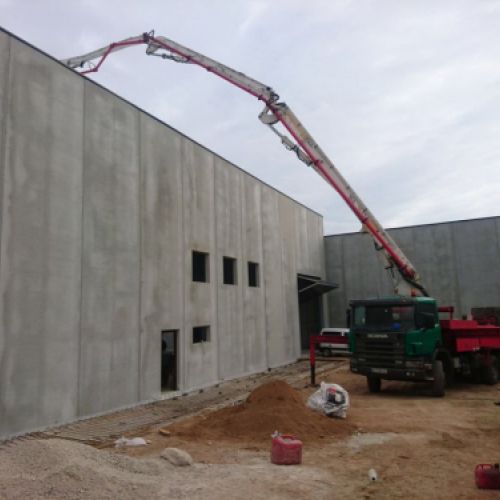 Camión bombeador en edificio en construcción