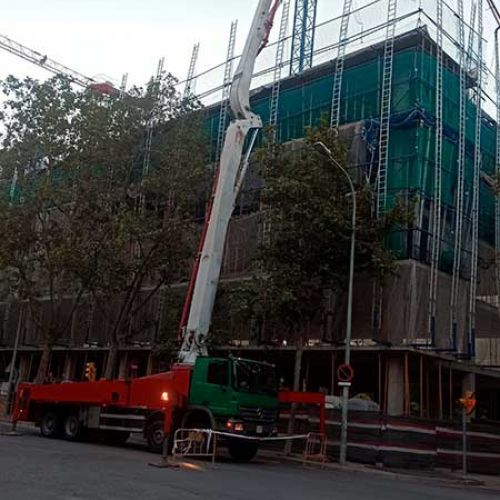 Edificio en construcción y camión de bombeo